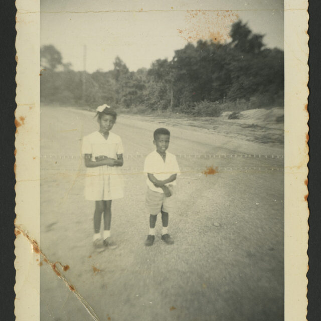 Young Venus Jones and her brother, Albert Jones, stand in the street together.