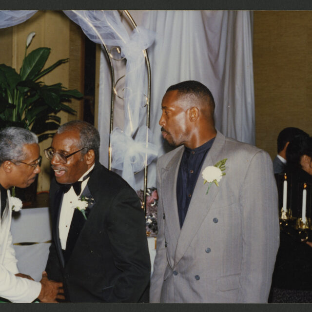 Albert Jones III, Venus' brother, her father, Albert Jones Jr., and her brother, Culbert Jones, talk to each other during the celebration of Albert Jr. and Bessie's 50th wedding anniversary.