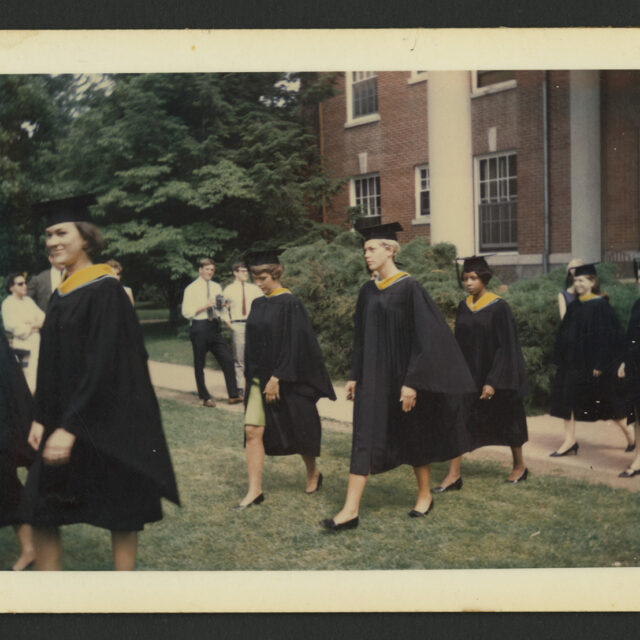 Venus Jones walks across the lawn with fellow graduates during her graduation from Mary Washington College.